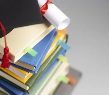 high-angle-stacked-books-graduation-cap-diploma-education-day.png